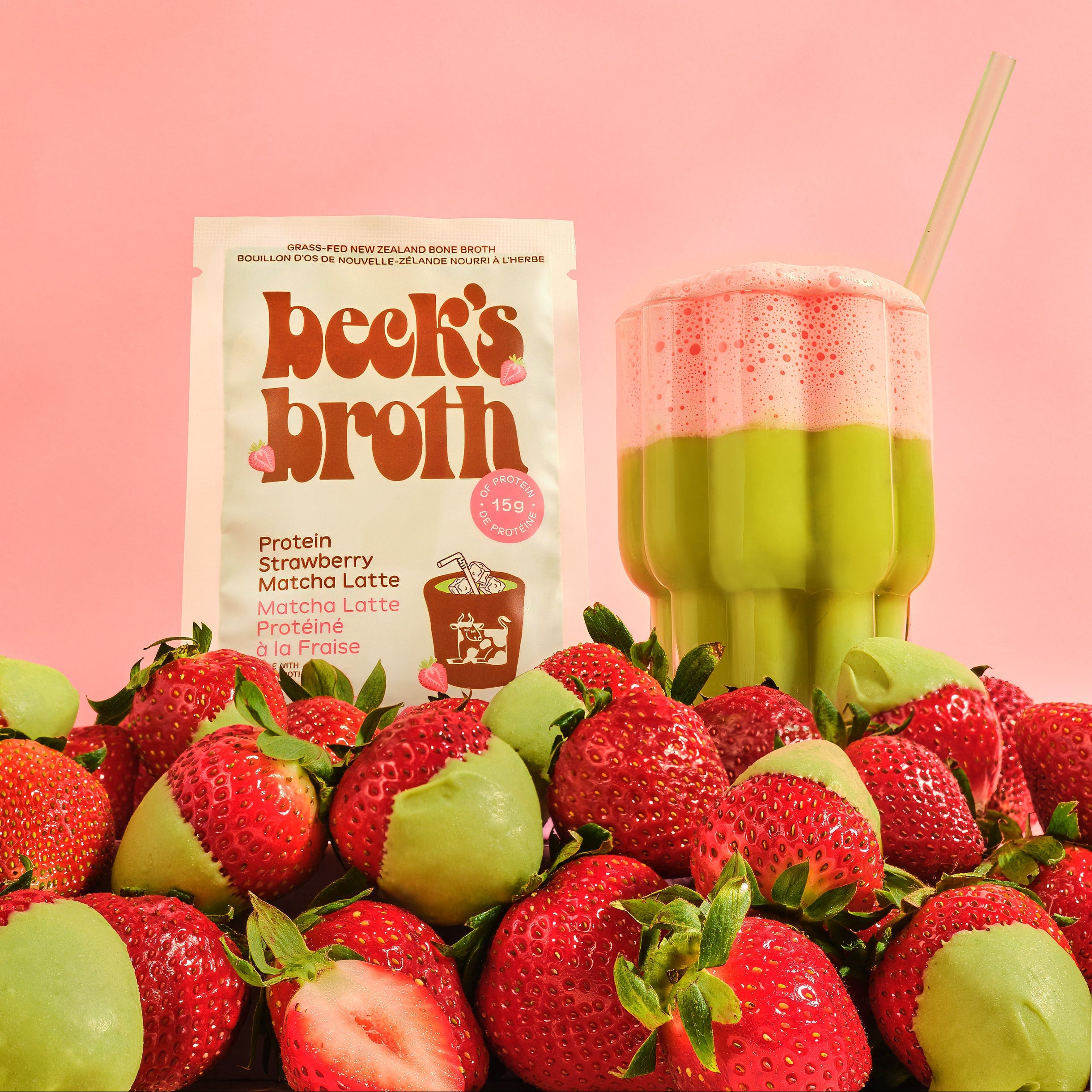 Beck's Broth package with a strawberry matcha and strawberries on a pink background